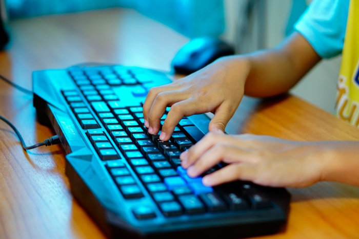 Image shows a child's hands on a computer keyboard.jpeg