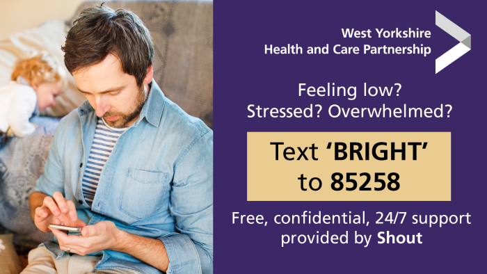 Man using a mobile phone. Text reads: feeling low, stressed, overwhelmed? Text 'BRIGHT' to 85258. Free confidential, 24/7 support provided by Shout